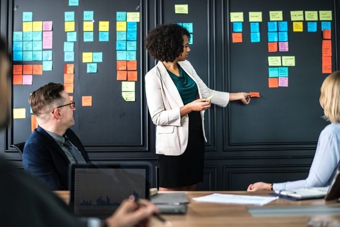 Team leader making notes of ideas at the front of a meeting